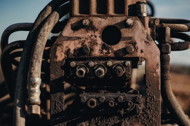 Rusted machinery block with bolts and hoses