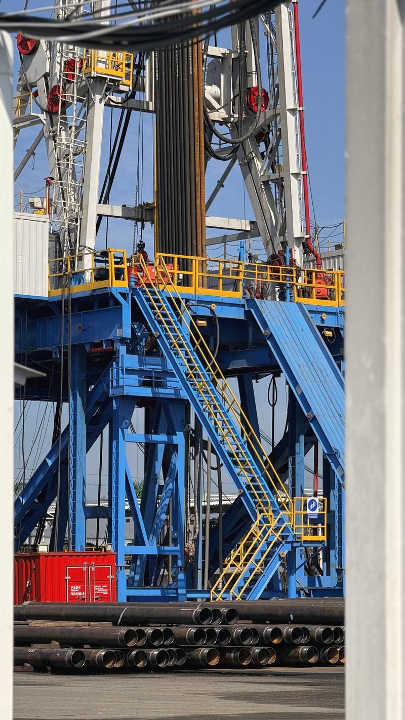 Blue rig substructure and stairs with pipe racked in front
